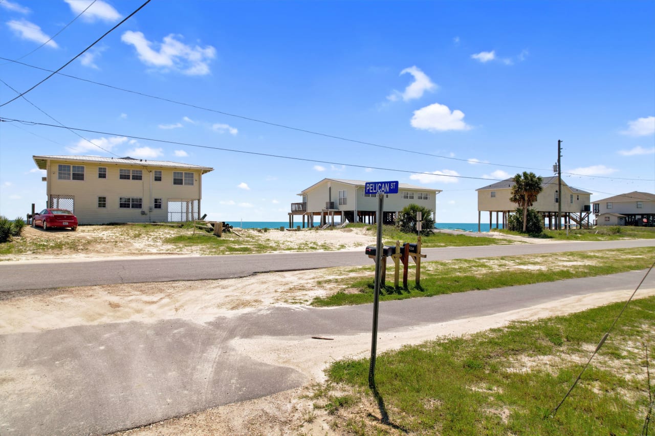 The coastal residential area showing houses near the water and the street in front.