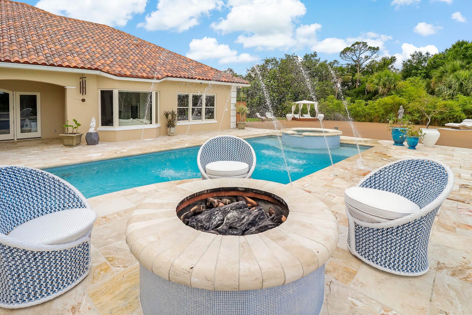 Poolside fire pit and fountain jets at a private Vero Beach estate