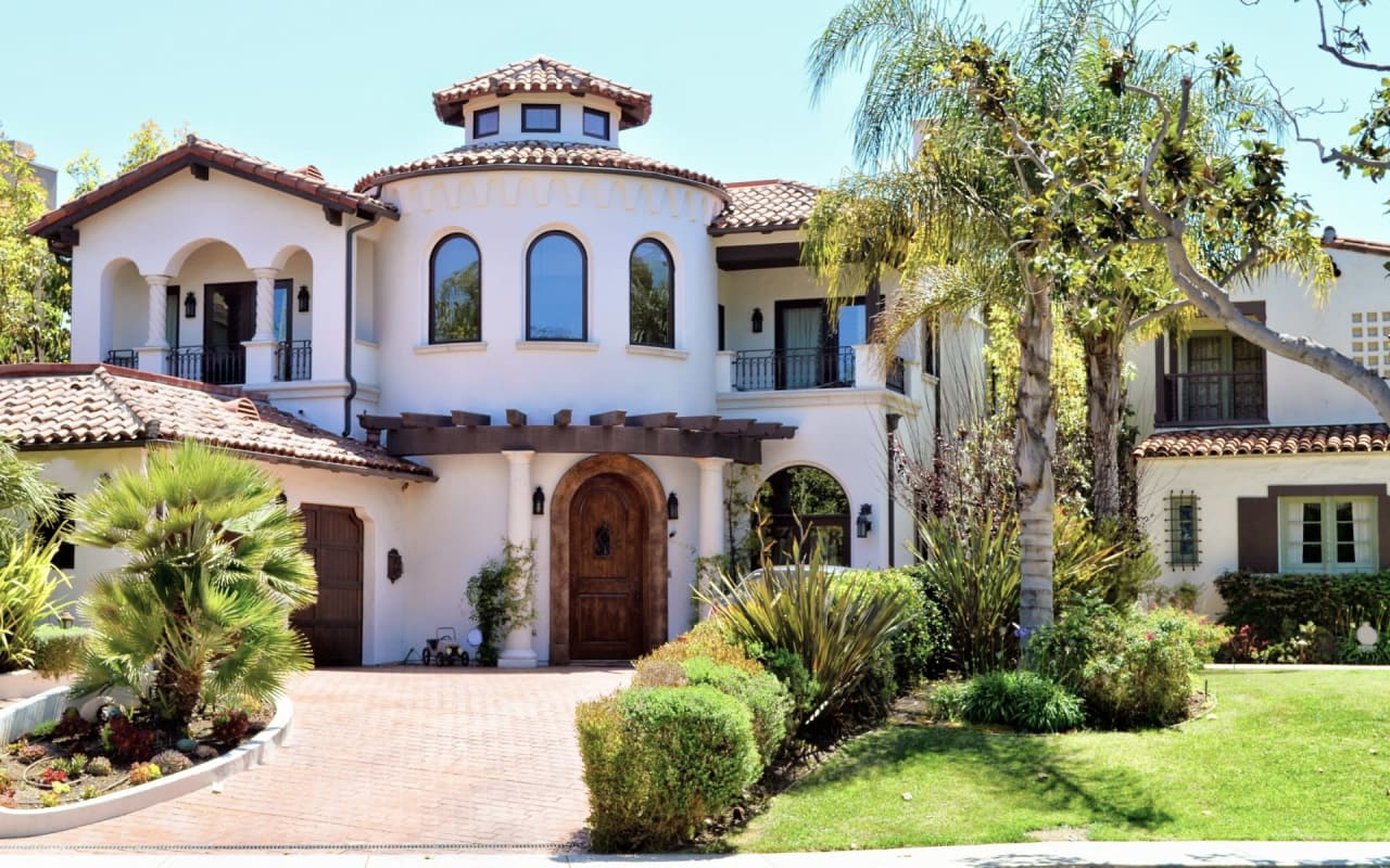 A Spanish-style home with a white stucco exterior and a terracotta tile roof.