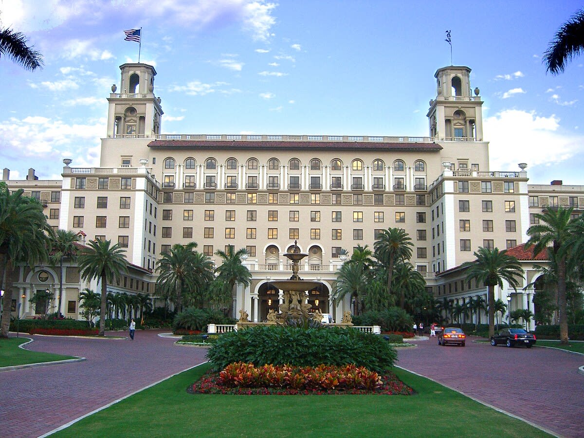 Breakers Hotel front with American Flags, fountains and palm trees