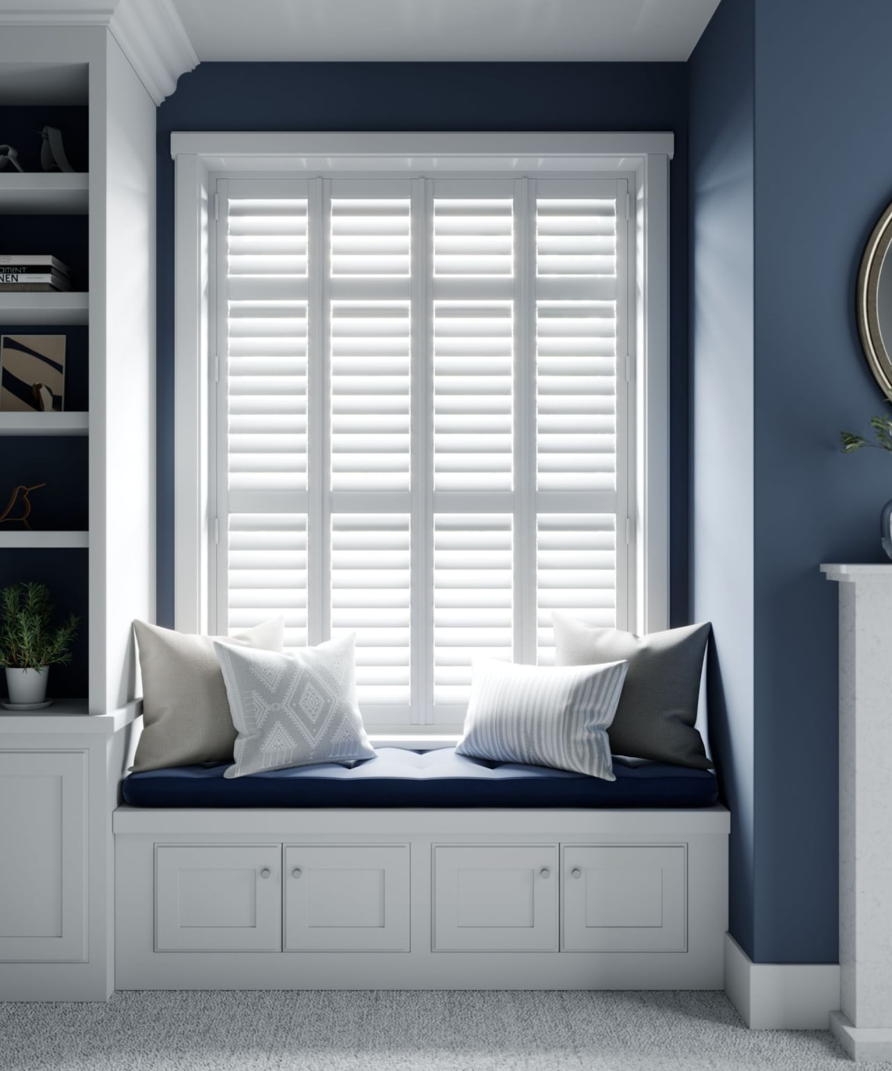 Cozy window seat with white shutters, blue cushions, and pillows in a blue and white-themed room.