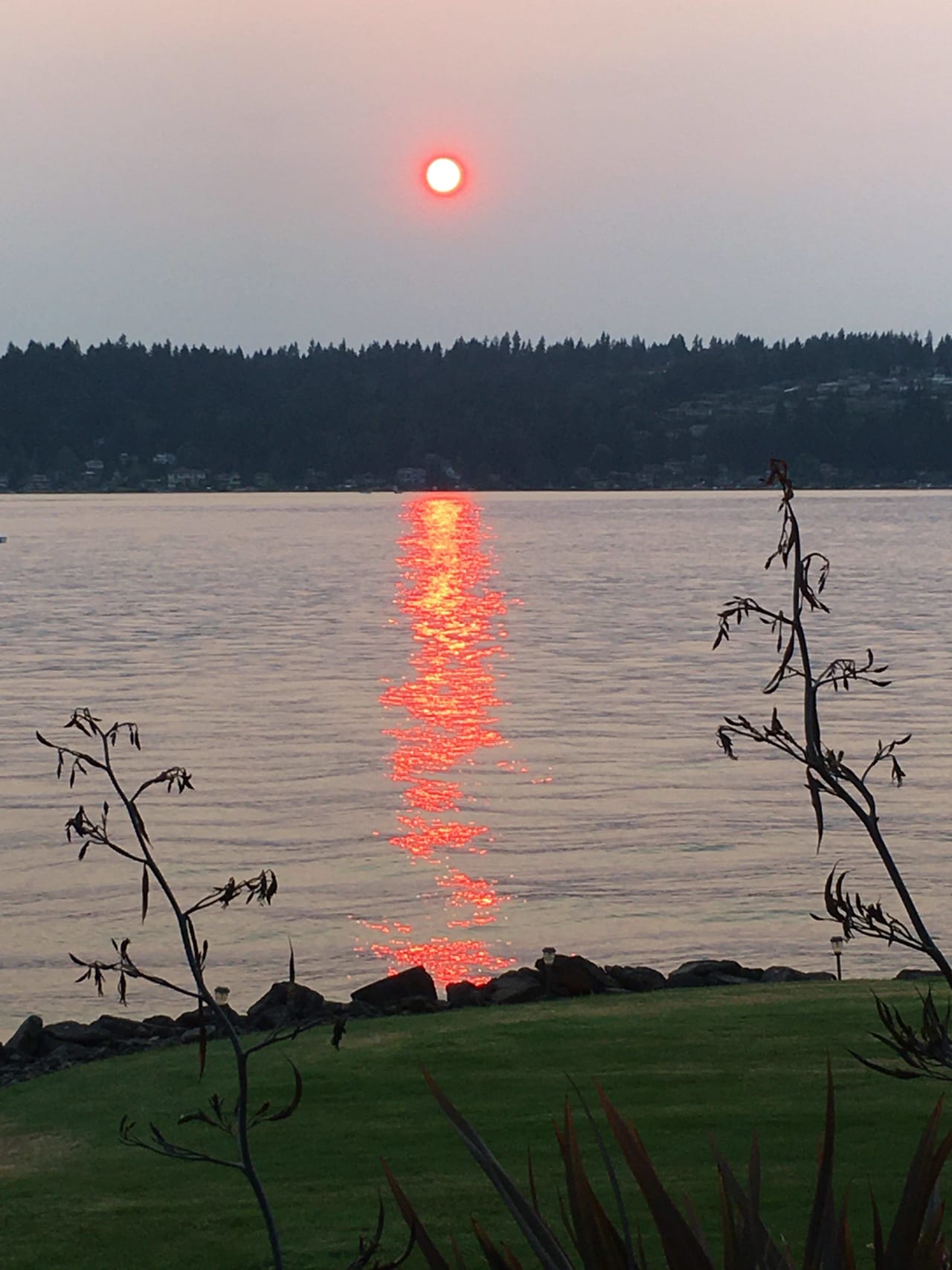 A lake with mountains and sunset in the background