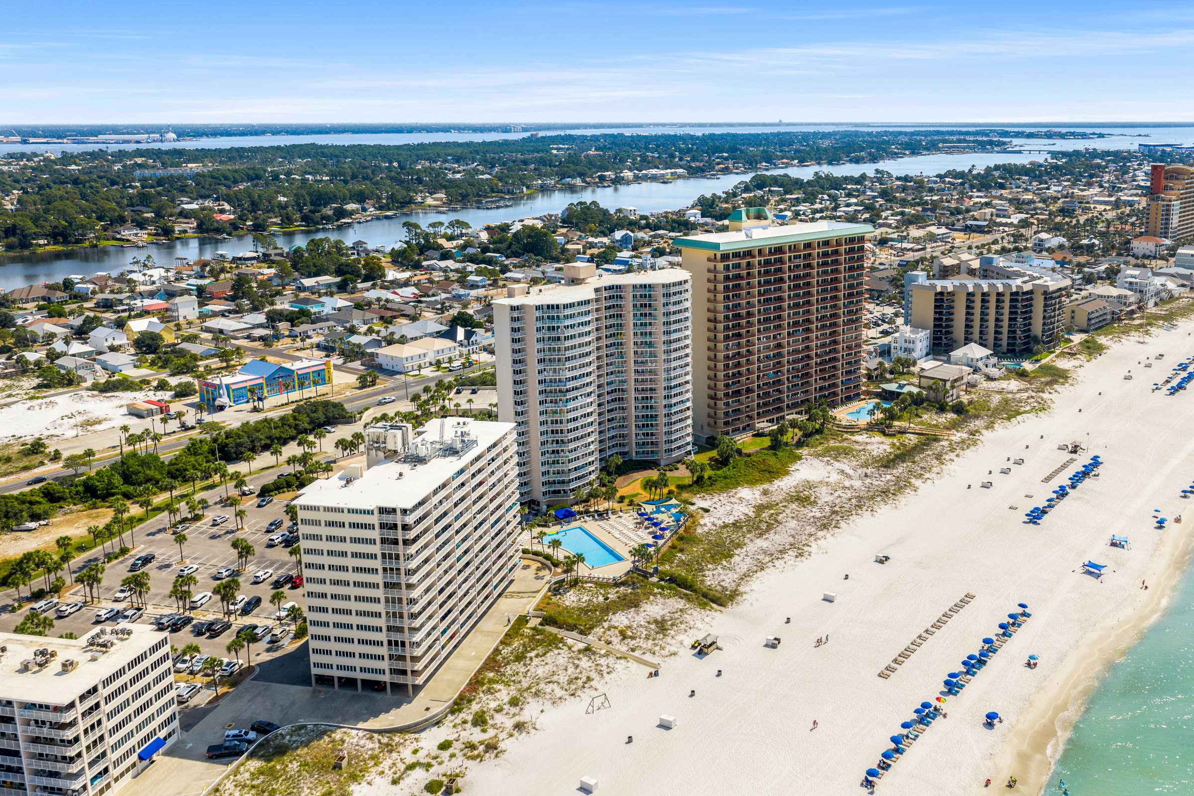 Wide aerial of Thomas Drive condos between the bay and the Gulf in Panama City Beach