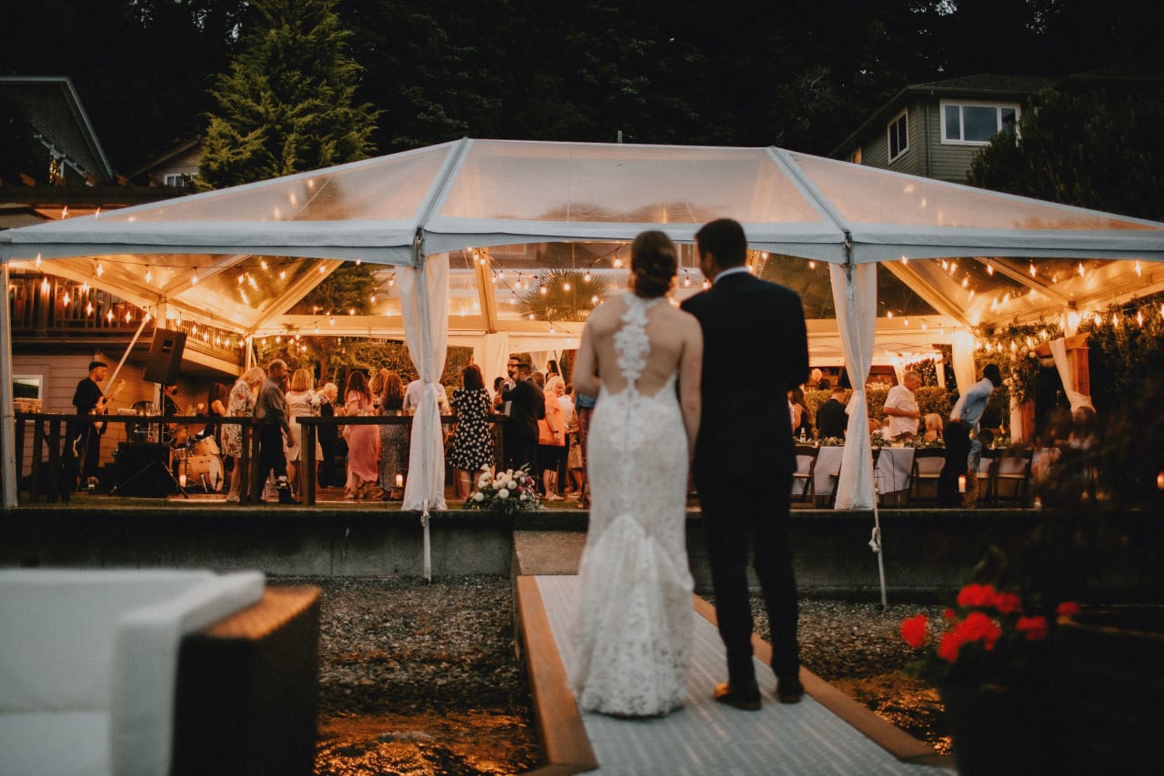 a newly wed couple walking towards the reception