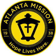 Logo of Atlanta Mission featuring a lantern, with the text "Hope Lives Here" and established date 1938.