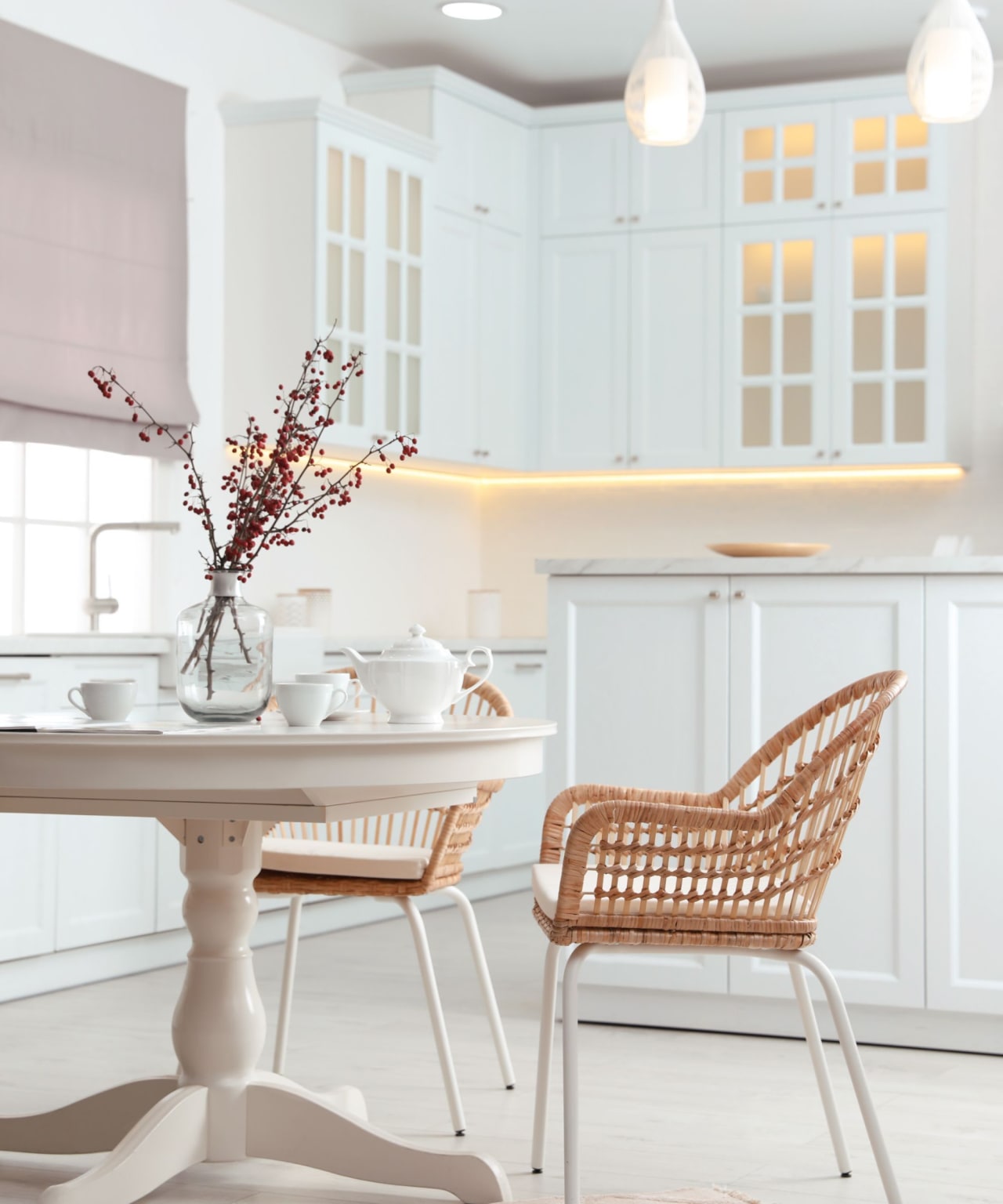 A modern kitchen with white cabinets and a round dining table