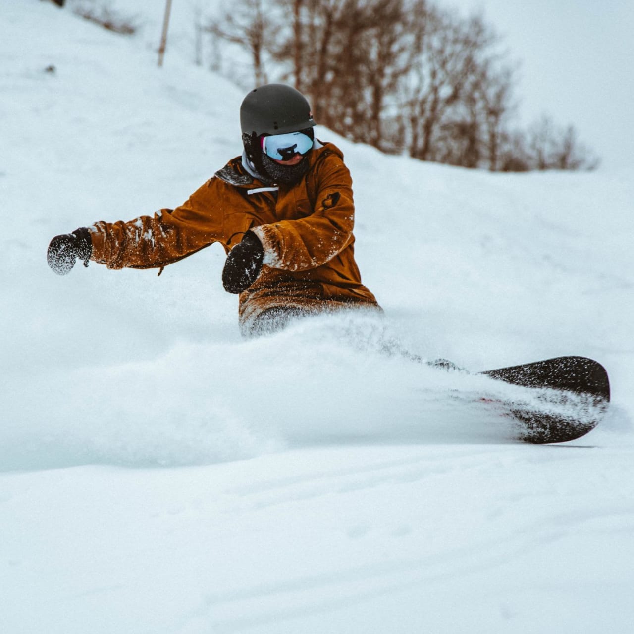 A snowboarder riding down a snowy slope.