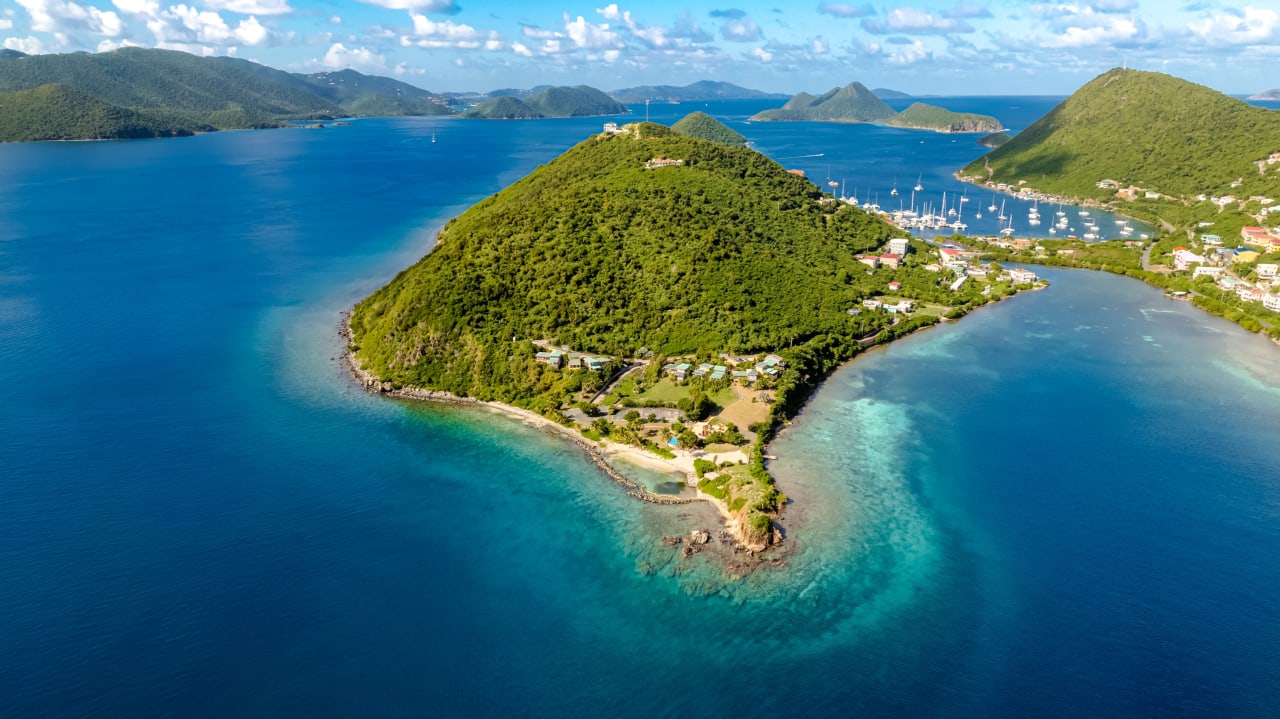 An aerial view of a small island in the middle of a turquoise ocean