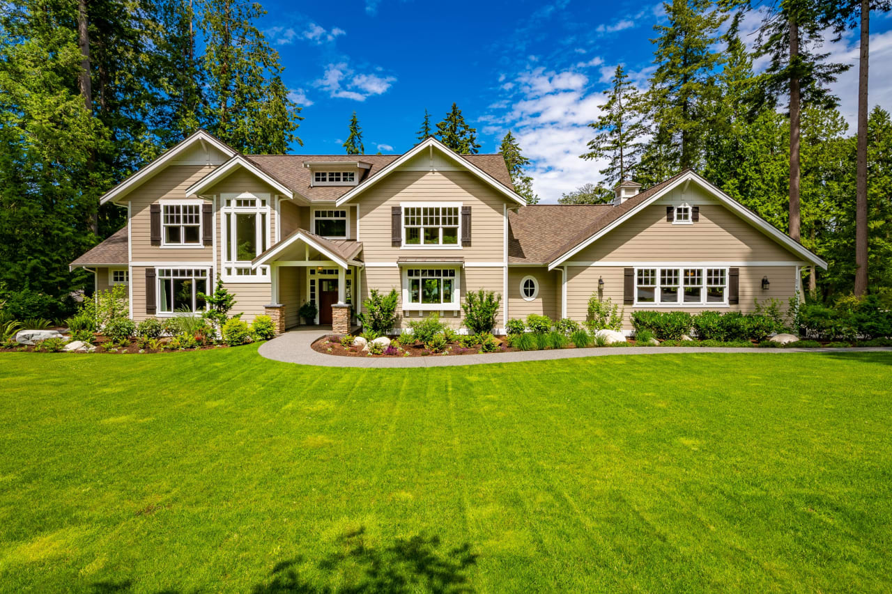 A two-story house with a beige exterior and a brown roof