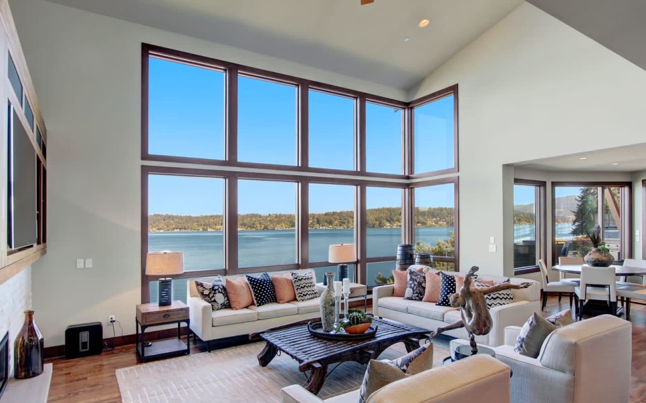 A modern living room with a large window overlooking a lake