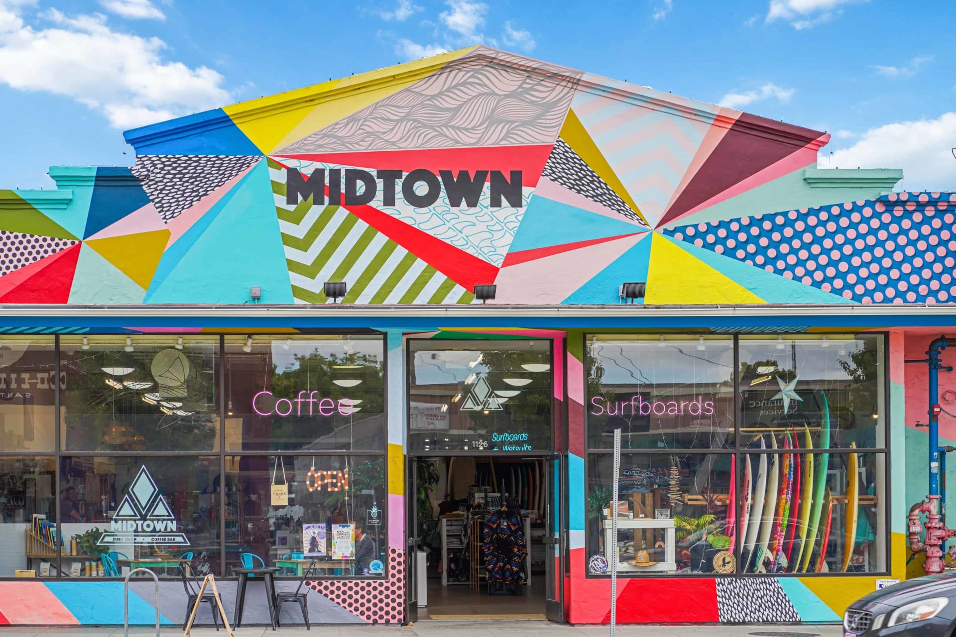 Midtown surf shop and coffee bar with a brightly patterned facade and surfboards in the windows.