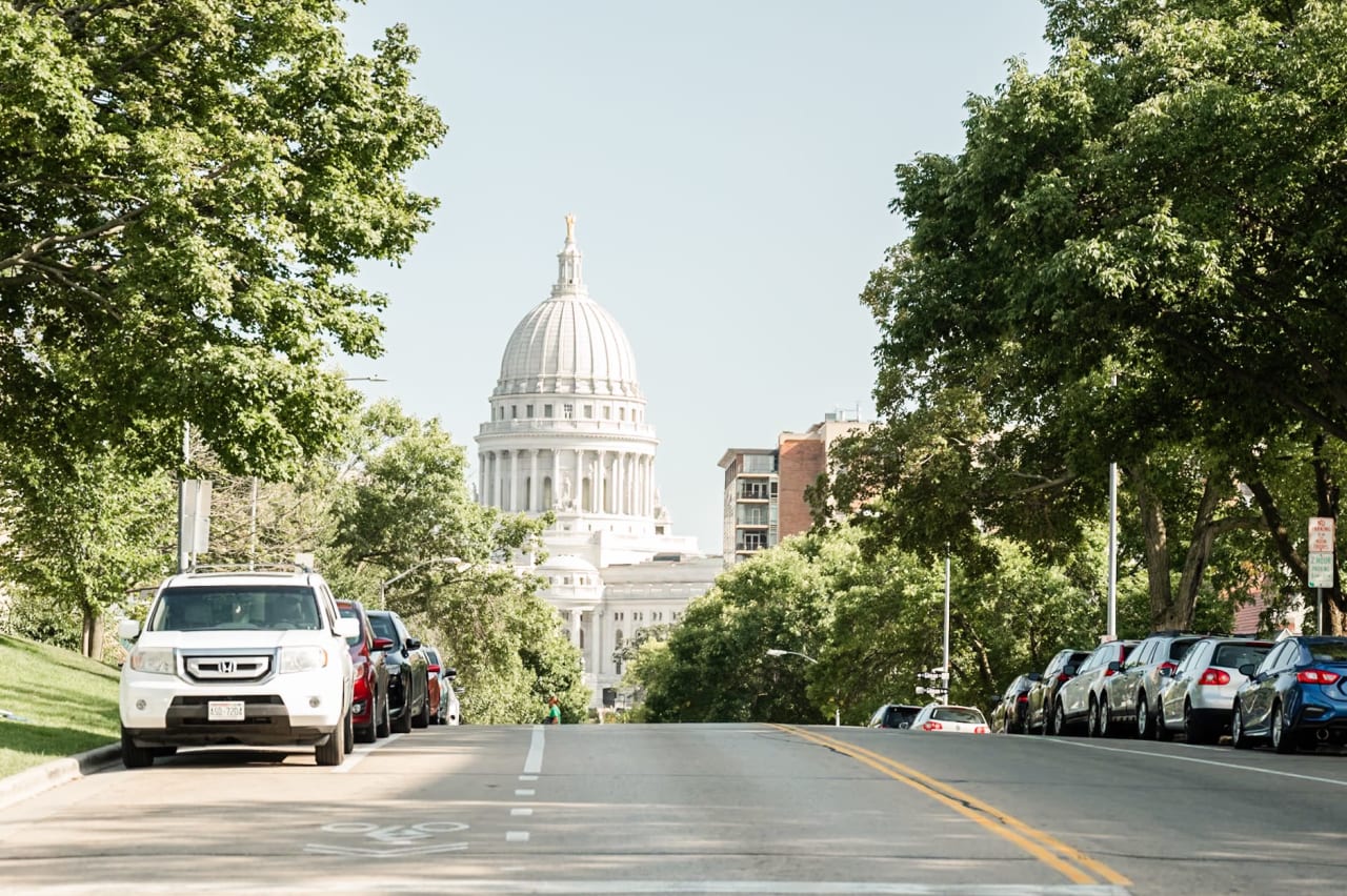 A view of the Wisconsin State Capitol building from a busy street in Madison, Wisconsin.