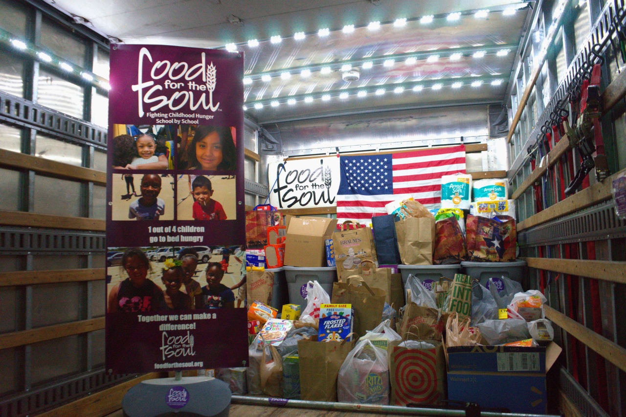 A truck filled with boxes and bags of food and a tarpaulin