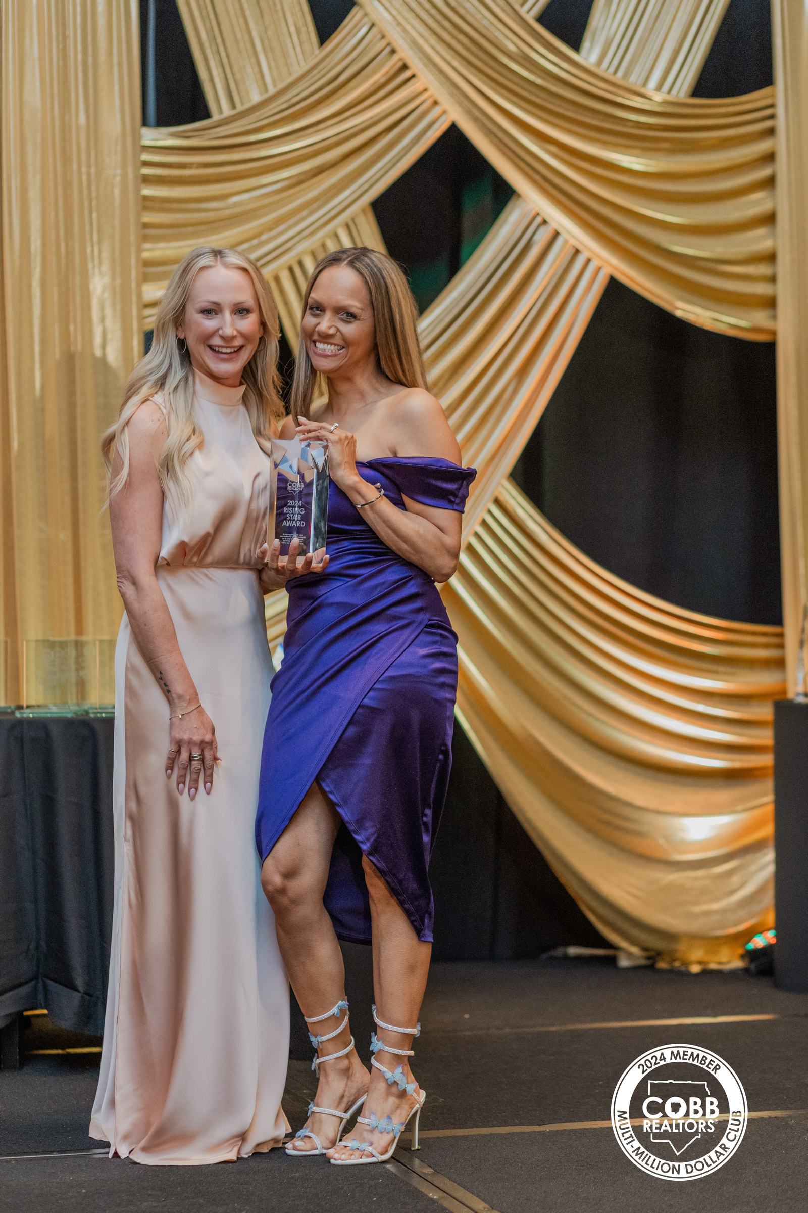 Lawana Ludd holding her Cobb Association of Realtors 2024 Rising Star Award trophy beside a presenter at the gala