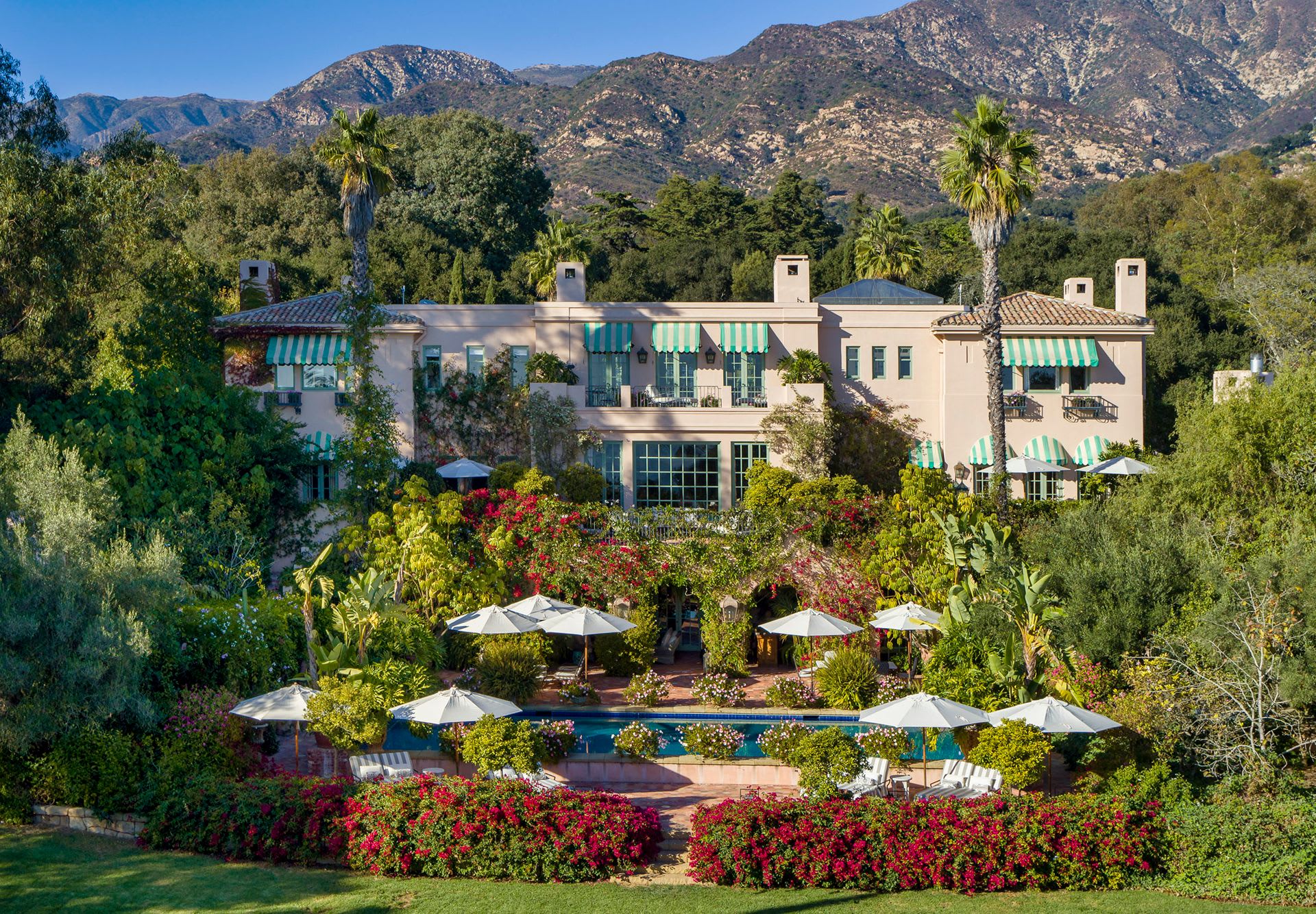 A large house surrounded by trees and flowers