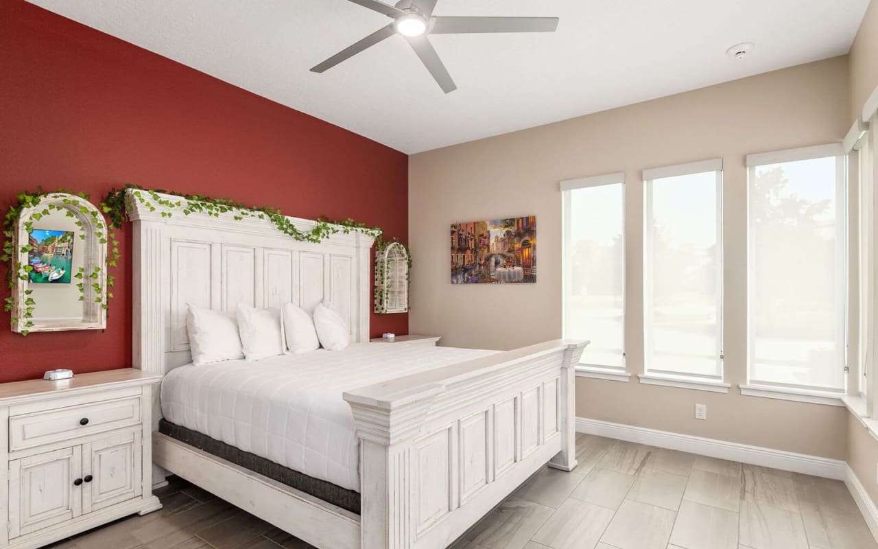 A bedroom interior with a queen-sized bed with a wooden headboard.