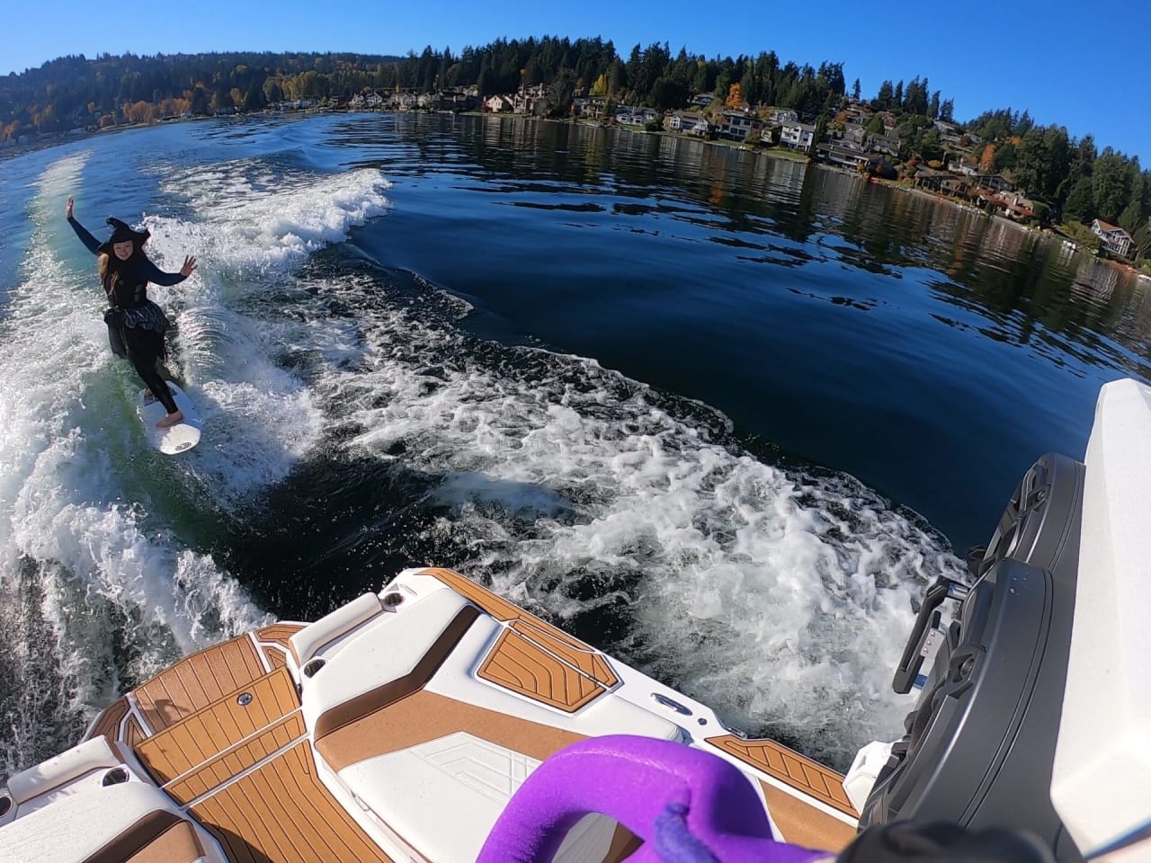 Woman wakeboarding behind a boat on a lake