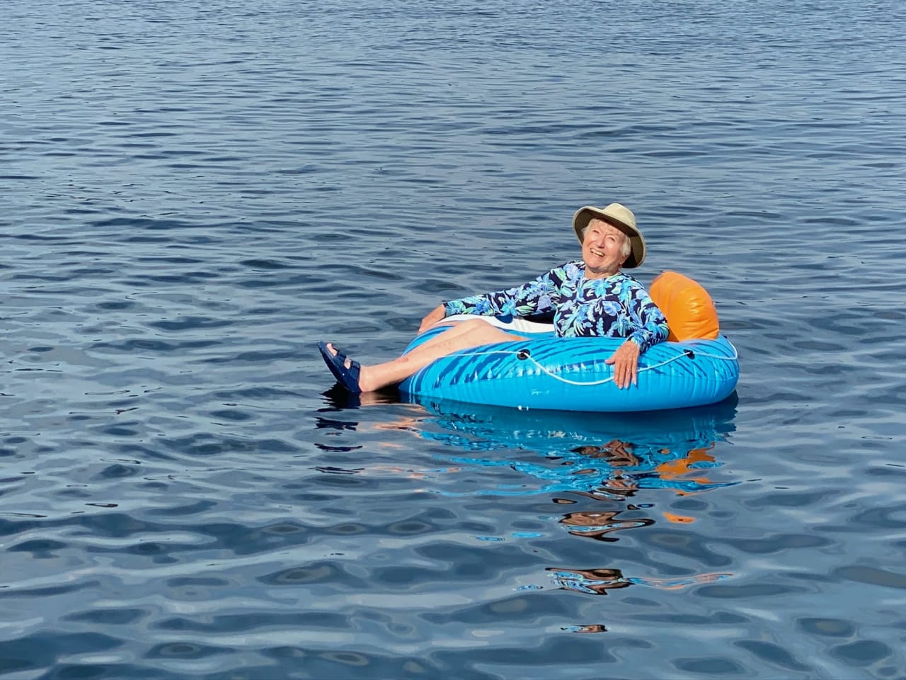 a woman riding in a blue floaters on a lake