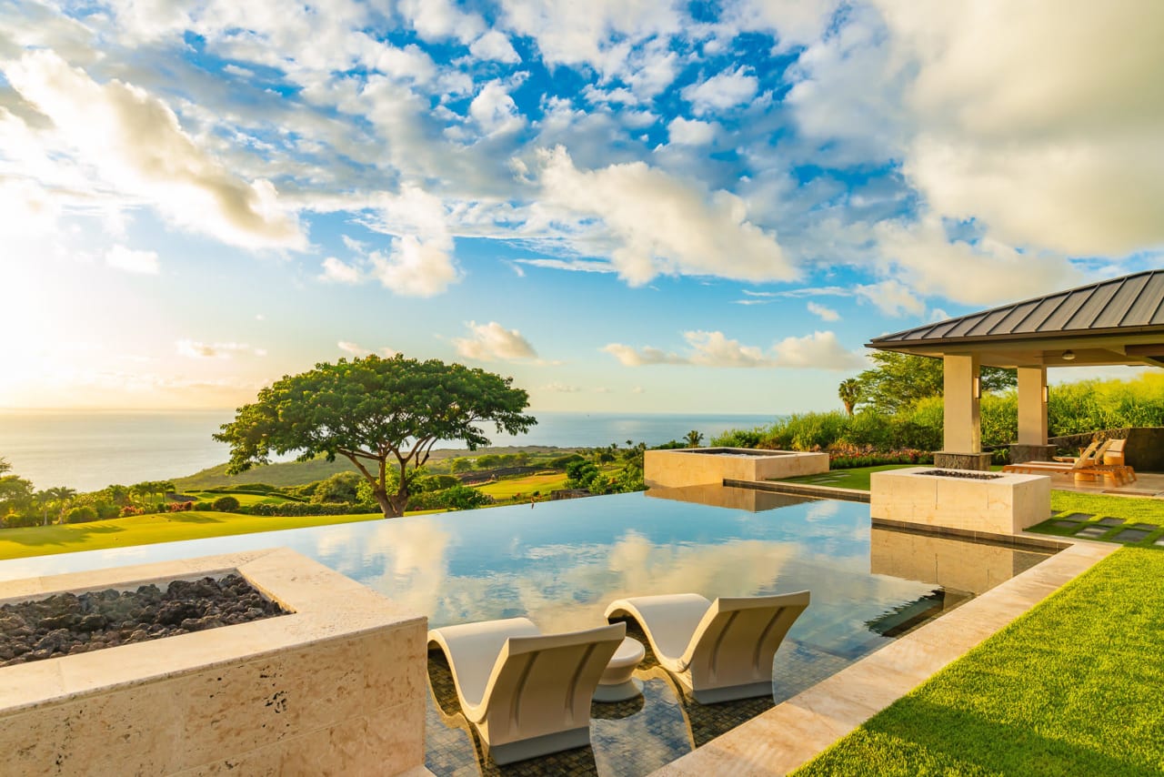 A luxurious swimming pool with stunning views of the ocean and the surrounding landscape