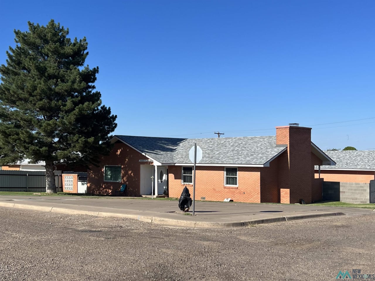 A red brick house with a stop sign in front of it.