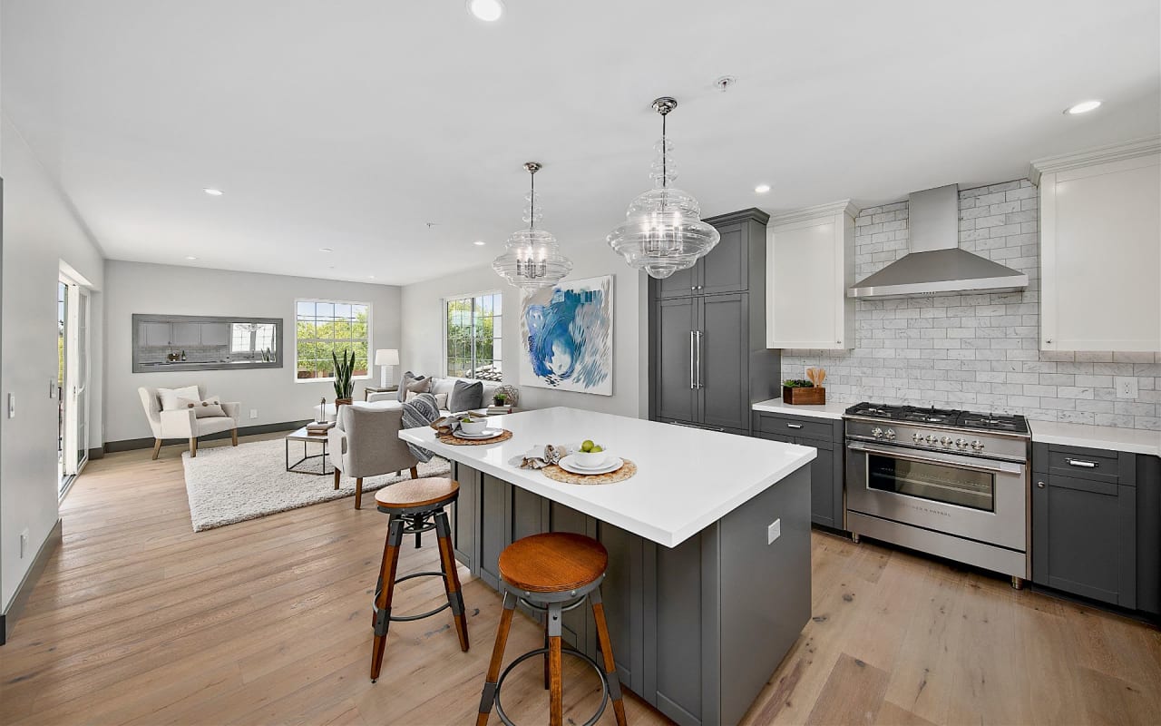 open living room and kitchen with wood floors and white and grey cabinets