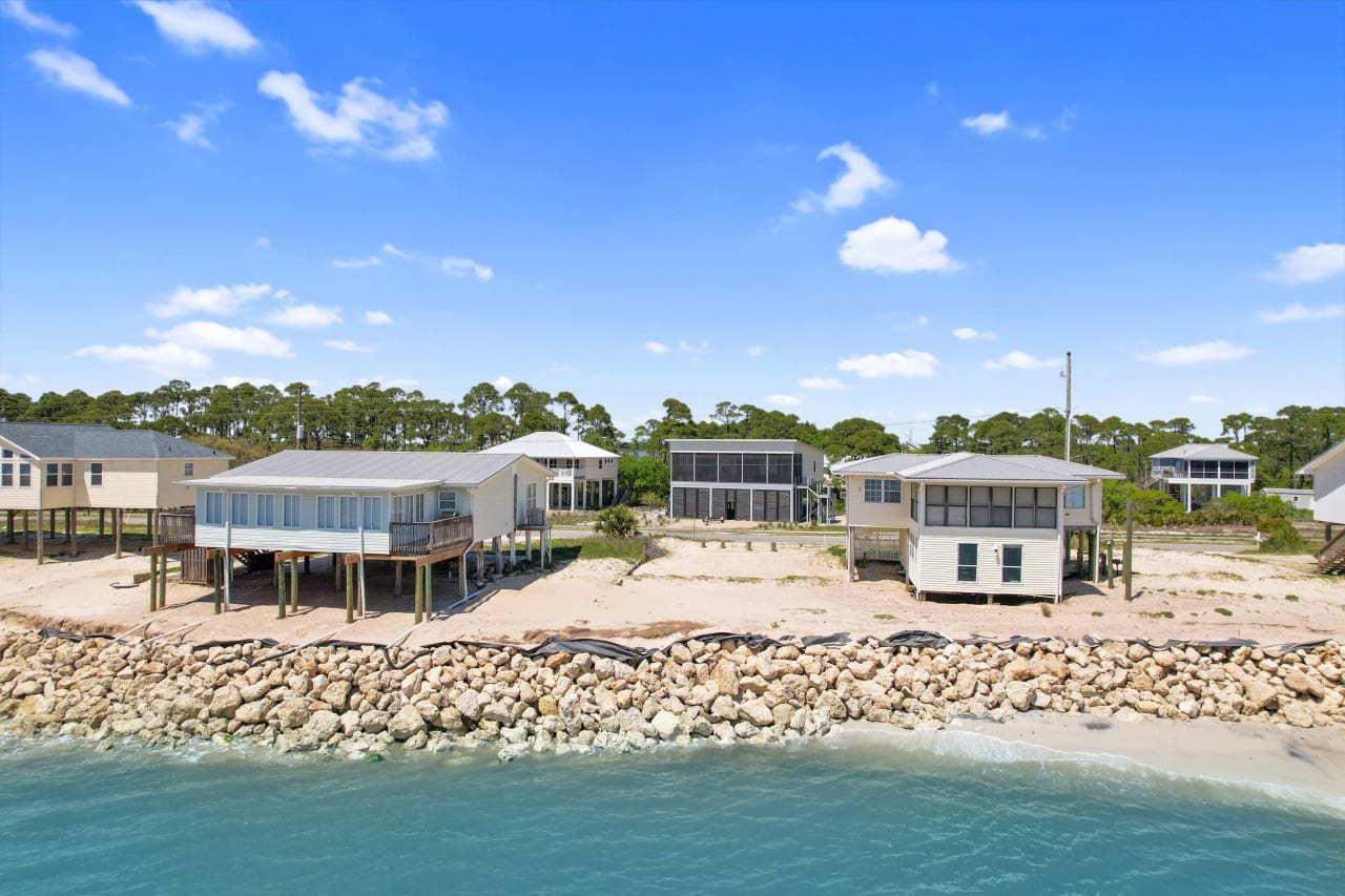 A drone image of the coastal residential area, showing houses built close to the water and a rocky shoreline.