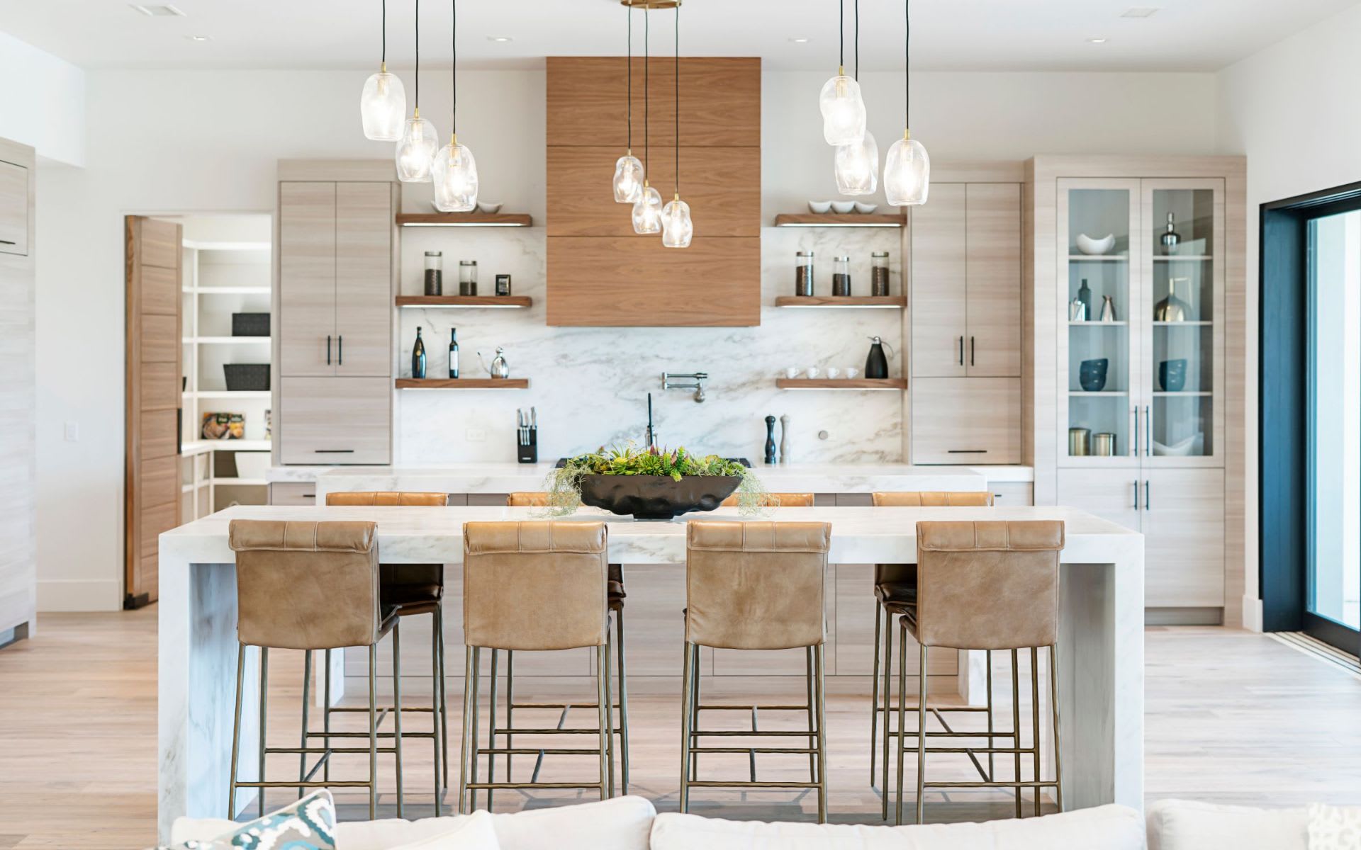 A kitchen with a marble island and stools