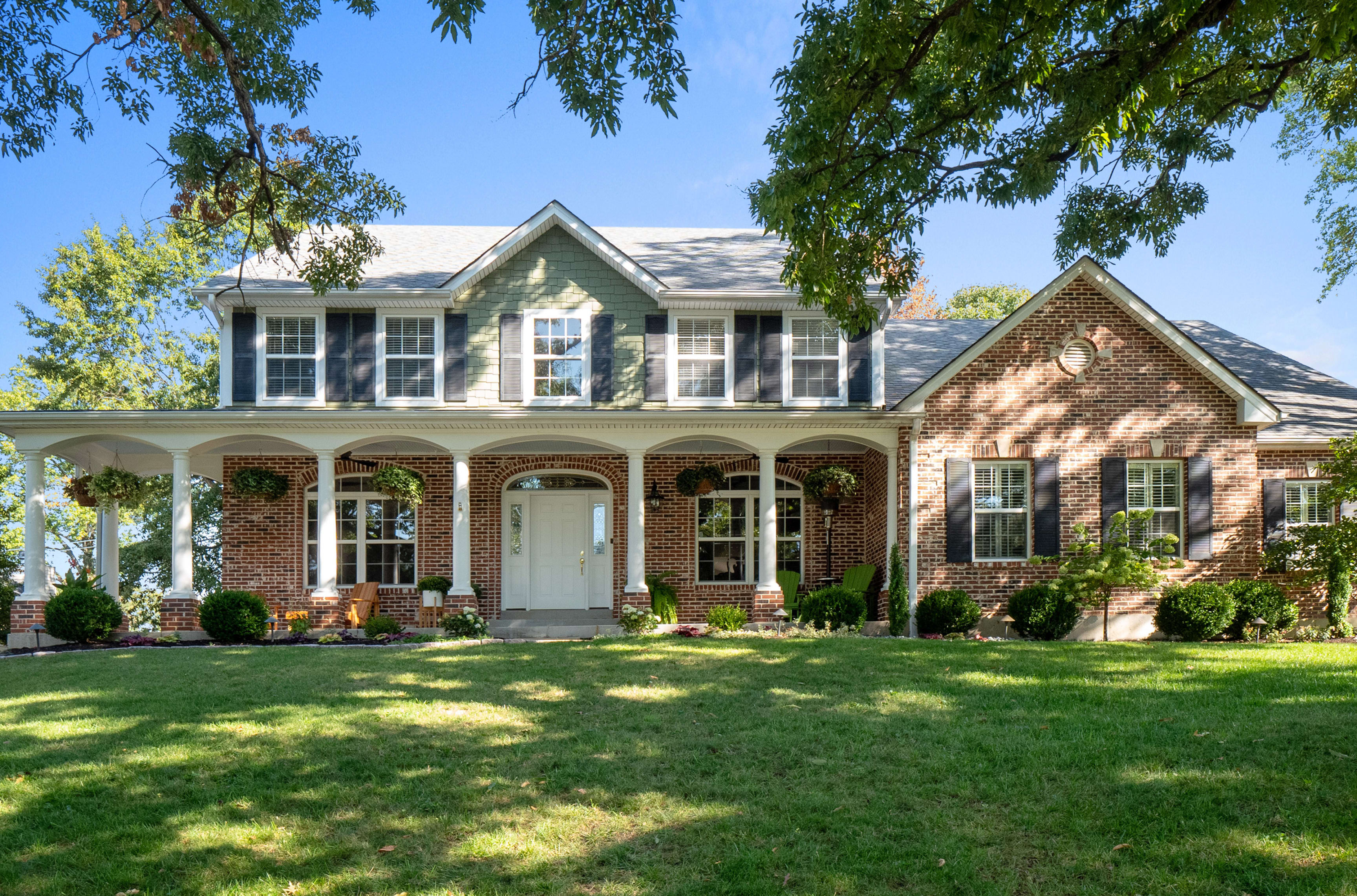 Impressive Des Peres home with wrap-around front porch.