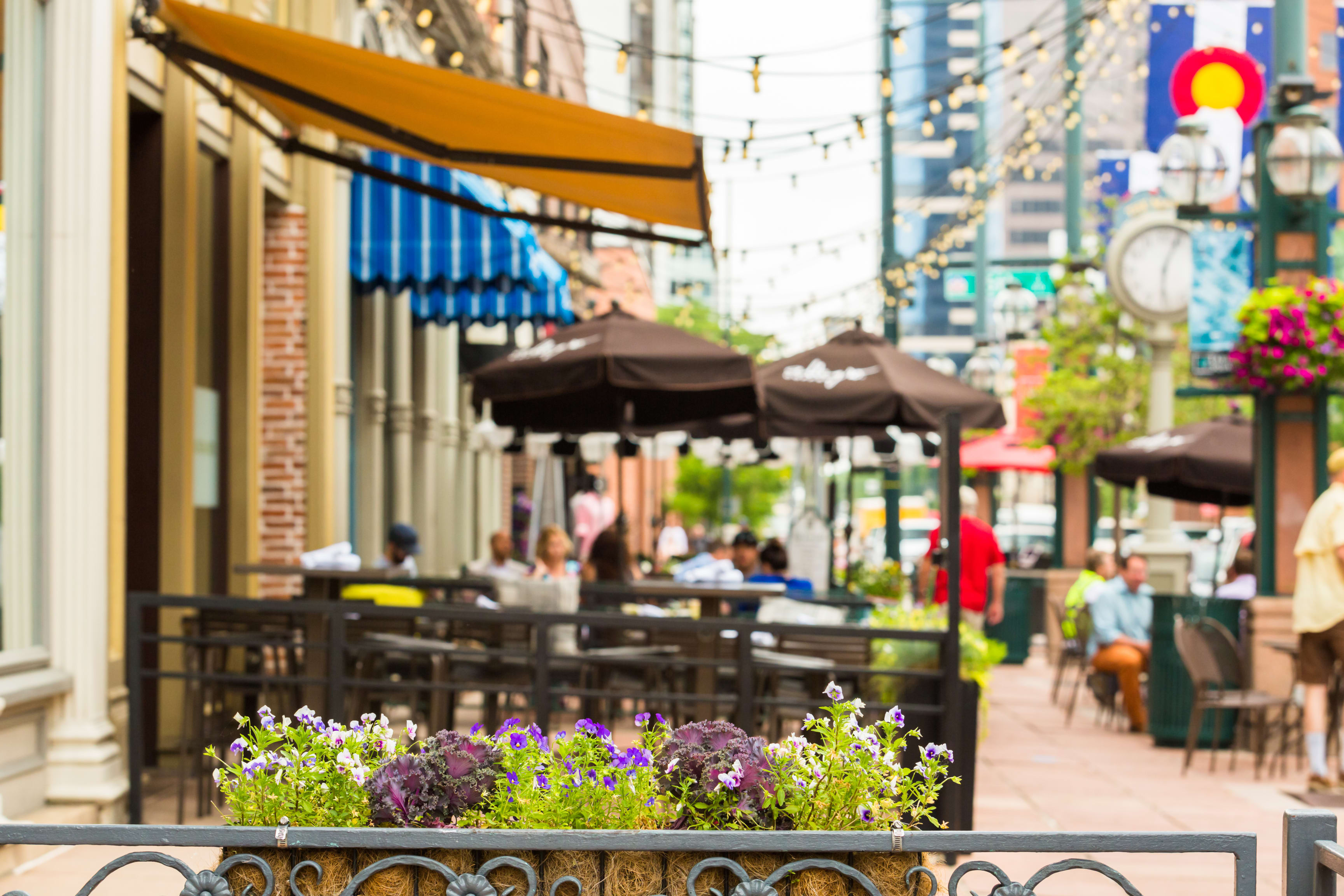 Bustling street with outdoor dining near residential condos adds a lively community vibe to urban living.