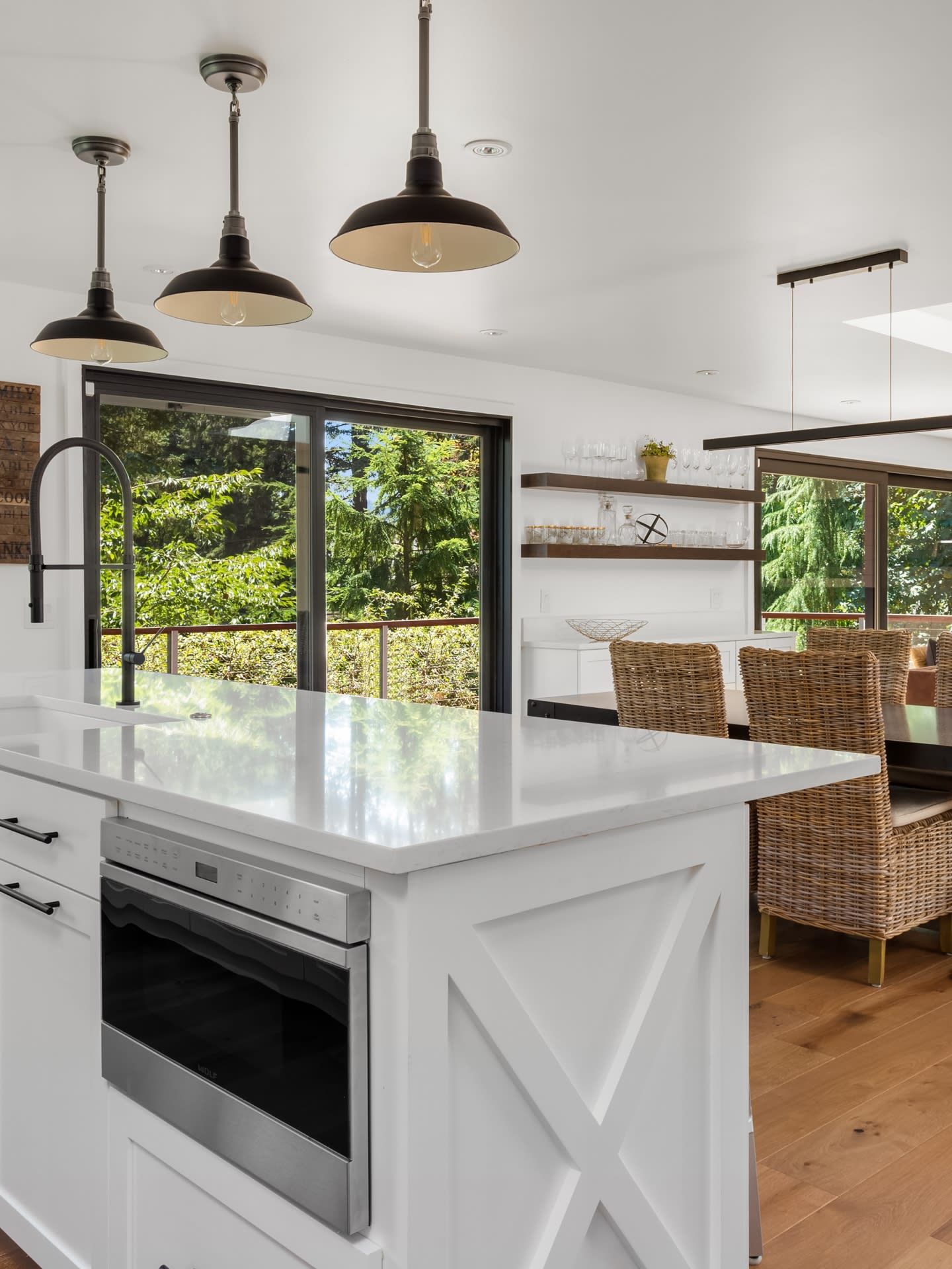  A view of a kitchen and dining room, with a sink, oven, and dining table visible. The kitchen backsplash is made of Ilkem marble