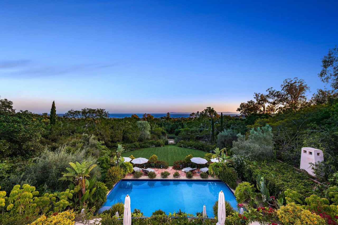 A large swimming pool surrounded by lush greenery