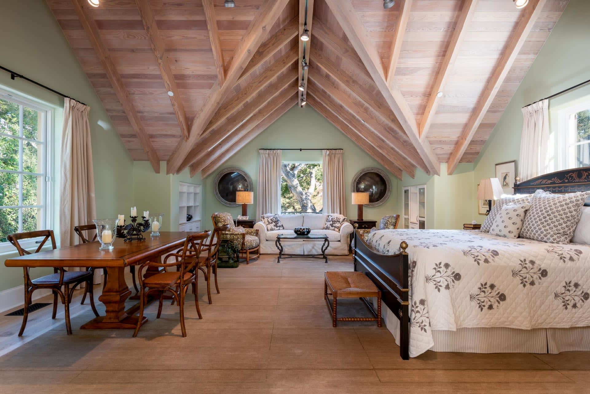 Bedroom with bed, table, chairs, and wooden ceiling