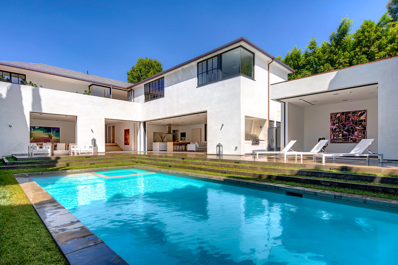 A large white house with a swimming pool in front of it