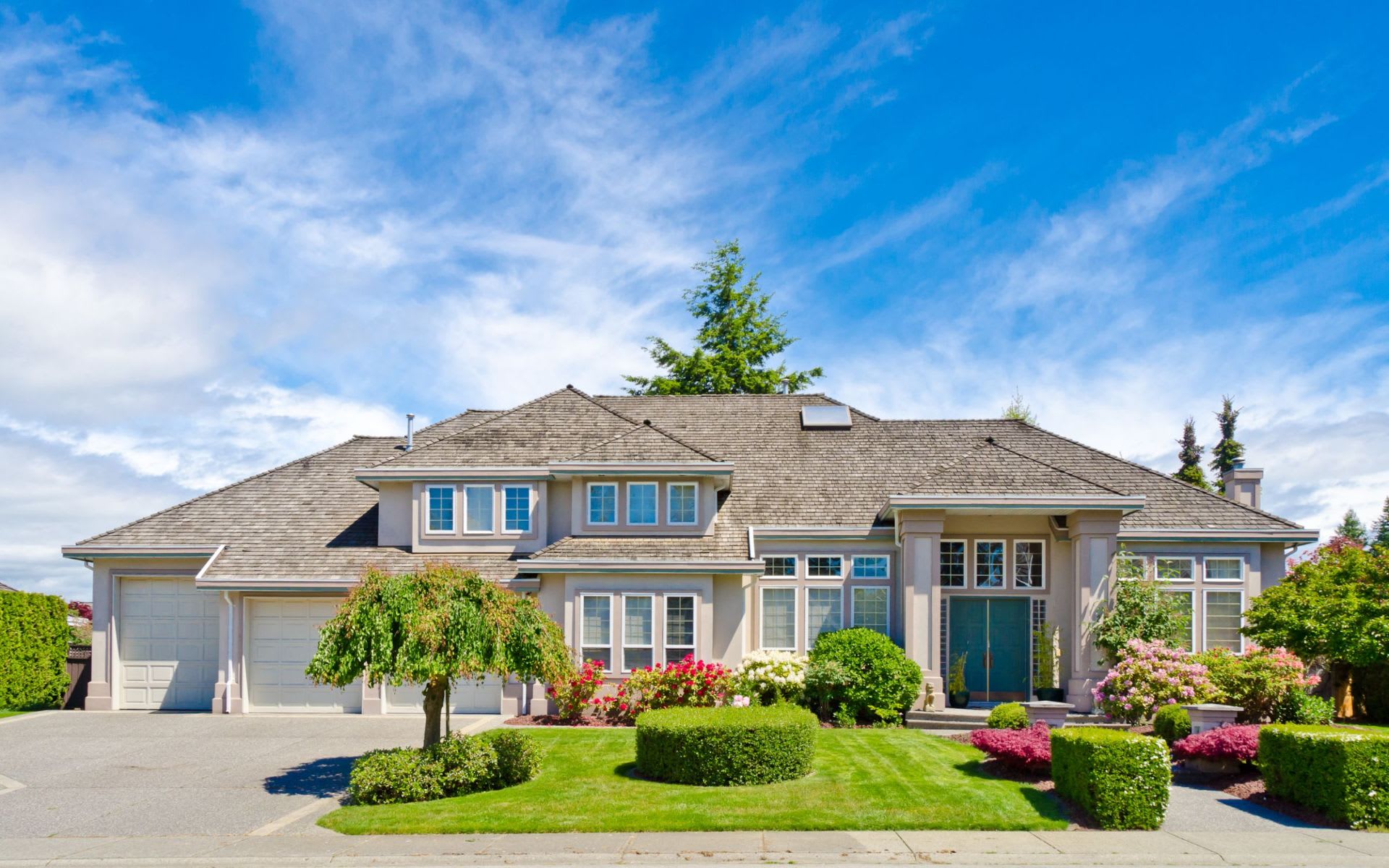 A large, spacious house with a lush green yard