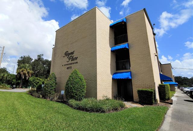 A multi-story residential apartment building with blue awnings in Regent Place